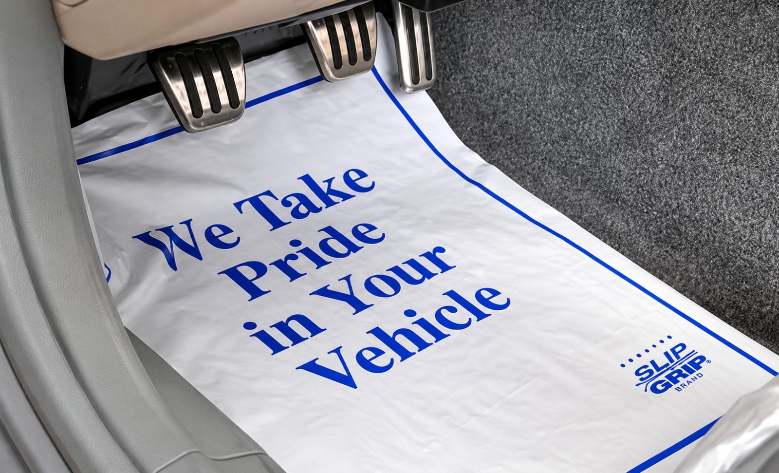 White Slip-N-Grip floor mat with blue We Take Pride in Your Vehicle print
