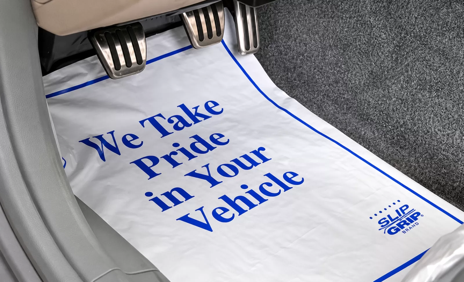 White Slip-N-Grip floor mat with blue We Take Pride in Your Vehicle print