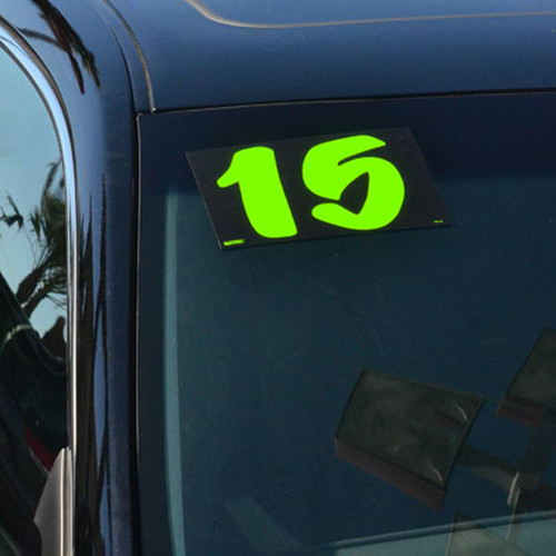 Chartreuse designer model-year sticker showing 15 on a dark vehicle windshield
