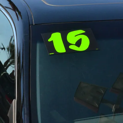 Chartreuse designer model-year sticker showing 15 on a dark vehicle windshield