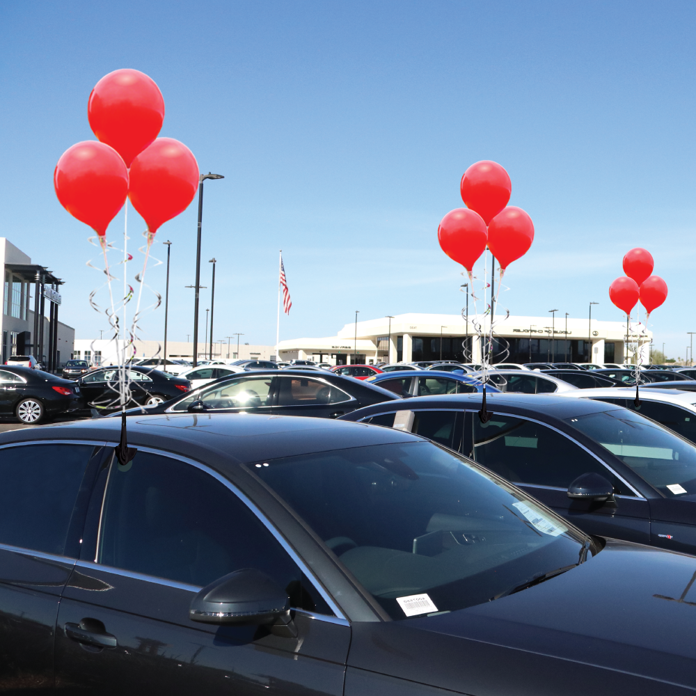 Three red PermaShine balloons mounted above a car window